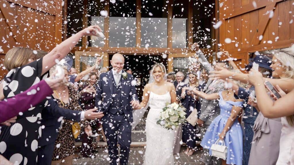 Bethany and Daniel being showered in confetti on their wedding day at the Tithe Barn , Petersfield, Hampshire