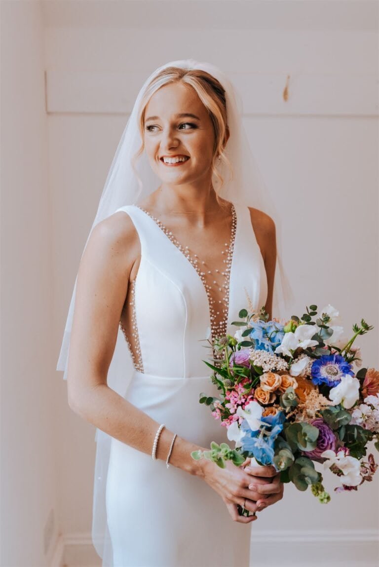 Portrait of the bride in natural light holding a colourful wildflower bouquet