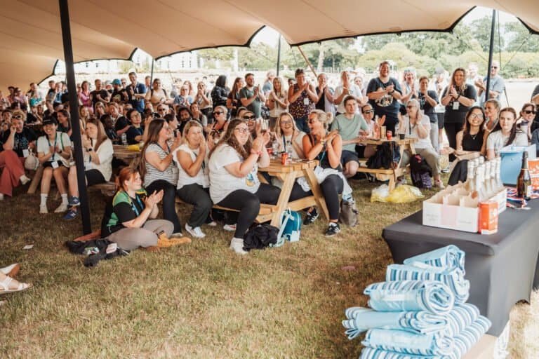 Guests gathered under a marquee at a corporate summer event