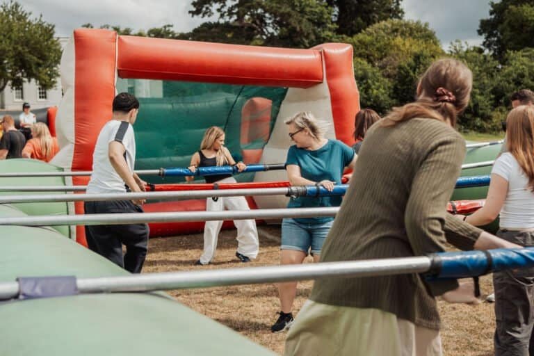 Staff taking part in a human table football game at a company away day