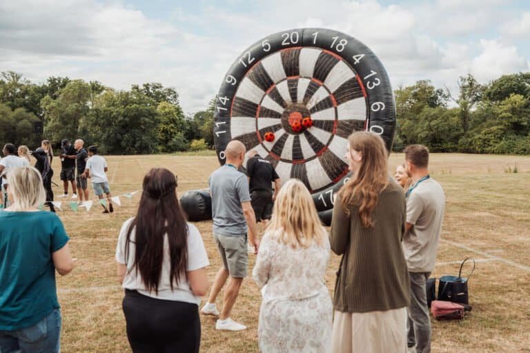 Employees playing giant darts at a corporate team building day