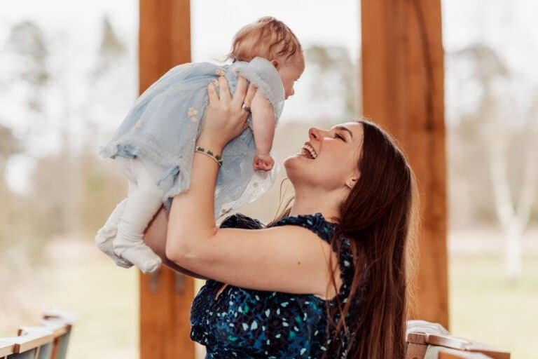 Mother lifting her baby up and laughing