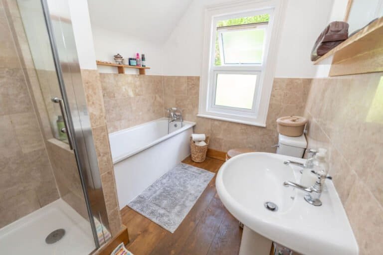 Family bathroom with bath and basin photographed for a property listing