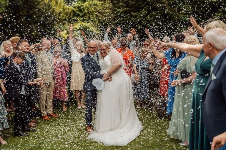 Guests lining up to throw confetti over the bride and groom