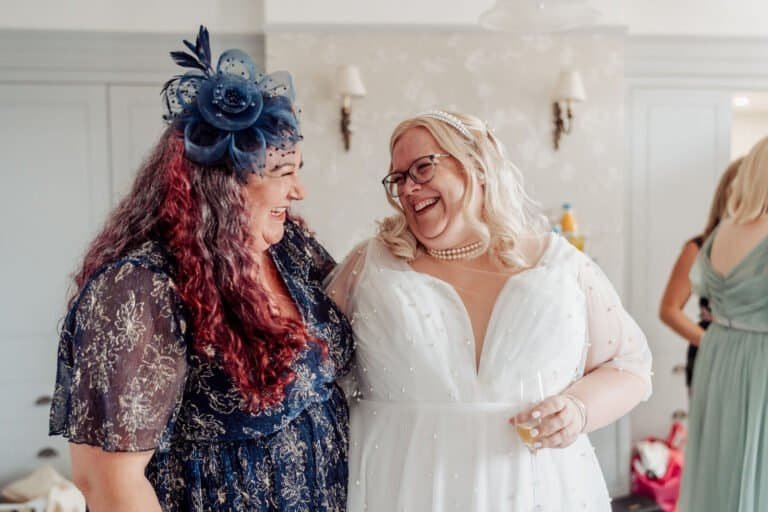 Bride laughing with a friend during the drinks reception