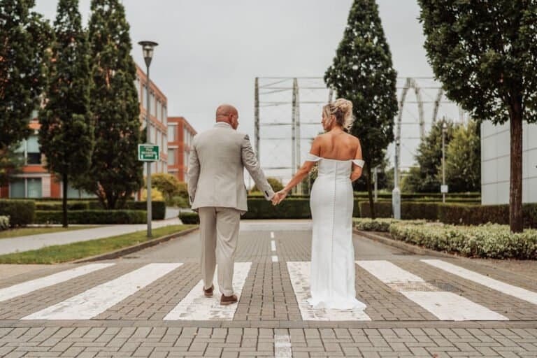 Bride and groom crossing a zebra crossing in full wedding dress