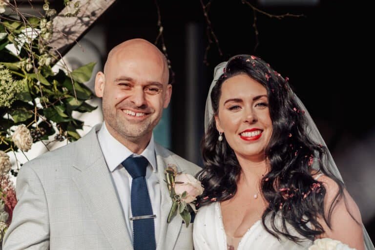 Evening portrait of the bride and groom against dark winter foliage